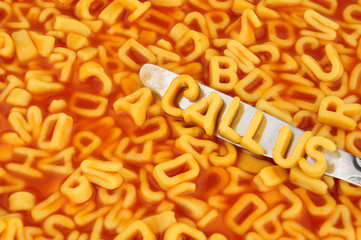 Alphabet spaghetti spelling call us with random letters in tomato sauce background