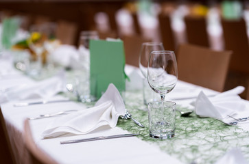 Decorated table on a gala dinner party with wine glasses and blurred out background