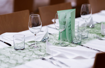 Decorated table on a gala dinner party with wine glasses and blurred out background