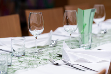 Decorated table on a gala dinner party with wine glasses and blurred out background