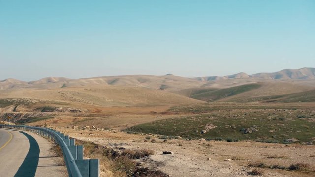 Maale Adumim, israel. car pass by, pan right to desert mountain view