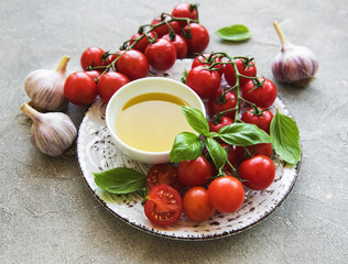 Plate with cherry tomatoes, olive oil and basil