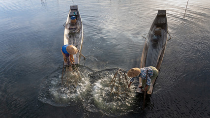  traditional Intha fisherman in long boat in the early morning on Lake Inle 
