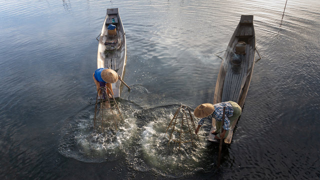  traditional Intha fisherman in long boat in the early morning on Lake Inle 