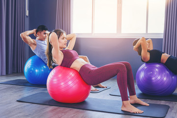 Fototapeta na wymiar Group of fit people working out in pilates class with fitness ball