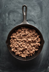 cooked ground beef in cast iron skillet flat lay composition