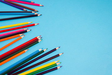 Color pencils scattered on a blue background