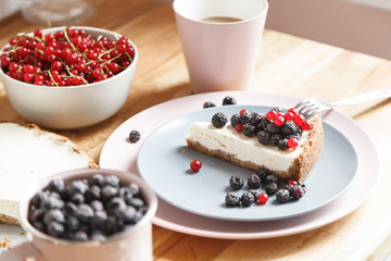 Slice of cheesecake with red currant and blackberries