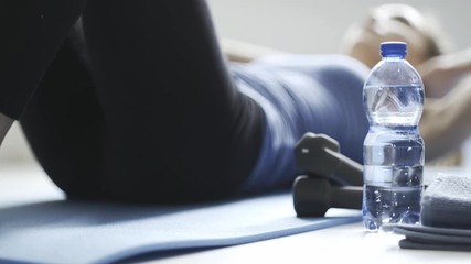 Young fit woman doing sit-ups on the floor