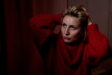 Portrait of a middle-aged woman in the room. Photography in the Studio. Photo shoot in a dark key