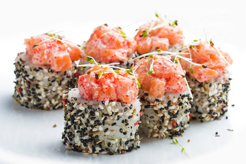 Sushi roll in sesame with smoked salmon and alfalfa