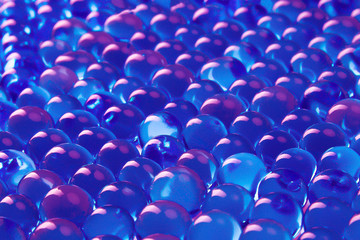 Background of dark blue with pink balls.Abstract texture of glass objects with reflection.