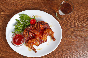 fried quail with red tomato-based sauce served with a glass of beer