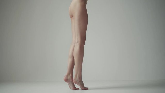 sexy female legs. back view. the girl is standing on tiptoes and shifting from foot to foot.