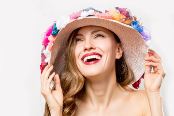 Beautiful summer woman wearing hat with flowers over light background