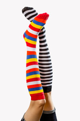  Funny woman legs in colorful different socks isolated over white