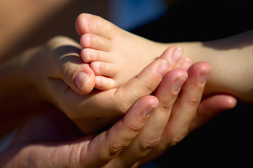 hands of mother and baby foot 