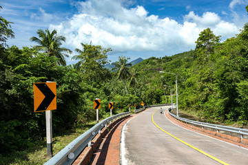 Koh Phangan, Thailand - December 19, 2018: Curvy road winding through beautiful jungle and coconut palm trees in Koh Phangan tropical island, a popular full moon party destination in Thailand