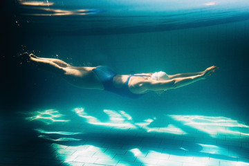 Obraz na płótnie Canvas Female swimmer at the swimming pool.Underwater photo.