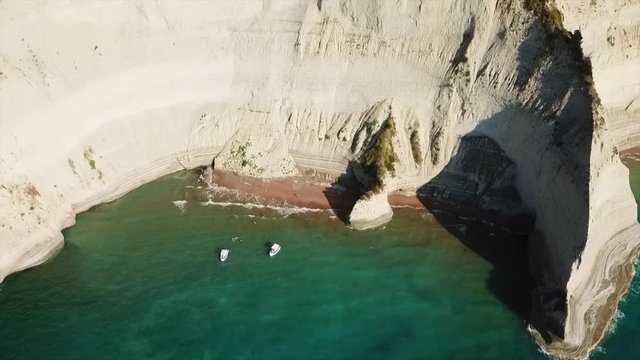 Aerial drone video of iconic white rock steep cliff volcanic bay of Cape Drastis and Peroulades area with tropical deep turquoise clear sea, Corfu island, Ionian, Greece