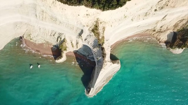 Aerial drone video of iconic white rock steep cliff volcanic bay of Cape Drastis and Peroulades area with tropical deep turquoise clear sea, Corfu island, Ionian, Greece