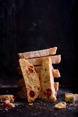 Delicious biscotti cookies with dried cherries and hazelnuts with black tea and white cup. Organic style. White cup of tea.