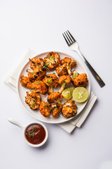 Tandoori Gobi / Roasted cauliflower Tikka is a dry dish made by roasting Cauliflowers in Oven/Tandoor. It's  popular starter food from India. served with ketchup. selective focus