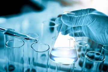 hand of scientist holding flask with lab glassware in chemical laboratory background, science...