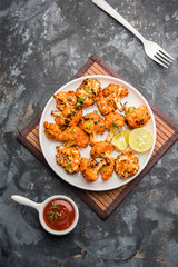 Tandoori Gobi / Roasted cauliflower Tikka is a dry dish made by roasting Cauliflowers in Oven/Tandoor. It's  popular starter food from India. served with ketchup. selective focus