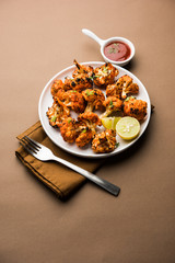 Tandoori Gobi / Roasted cauliflower Tikka is a dry dish made by roasting Cauliflowers in Oven/Tandoor. It's  popular starter food from India. served with ketchup. selective focus