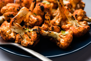 Tandoori Gobi / Roasted cauliflower Tikka is a dry dish made by roasting Cauliflowers in Oven/Tandoor. It's  popular starter food from India. served with ketchup. selective focus