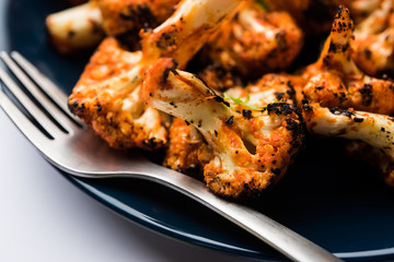 Tandoori Gobi / Roasted cauliflower Tikka is a dry dish made by roasting Cauliflowers in Oven/Tandoor. It's  popular starter food from India. served with ketchup. selective focus