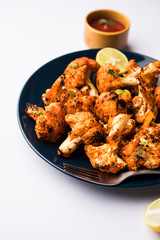 Tandoori Gobi / Roasted cauliflower Tikka is a dry dish made by roasting Cauliflowers in Oven/Tandoor. It's  popular starter food from India. served with ketchup. selective focus