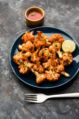 Tandoori Gobi / Roasted cauliflower Tikka is a dry dish made by roasting Cauliflowers in Oven/Tandoor. It's  popular starter food from India. served with ketchup. selective focus