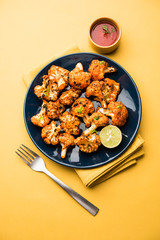 Tandoori Gobi / Roasted cauliflower Tikka is a dry dish made by roasting Cauliflowers in Oven/Tandoor. It's  popular starter food from India. served with ketchup. selective focus