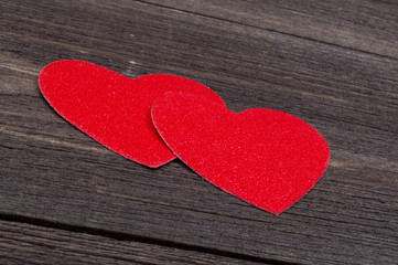 Obraz premium Two paper hearts on a wooden table on Valentine's Day
