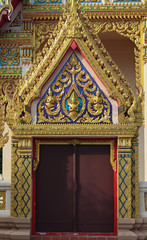 Fototapeta na wymiar Beautiful gold and unique Thai Buddha style. Sun shine from the left to a gate of a Temple and make shade. Look mysterious 