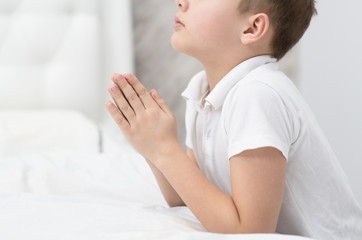 Young boy praying at home