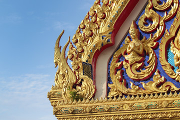 Fototapeta na wymiar Bold and beautiful architecture of a Thai temple style decorating with golds and metals. Statues showing Thai greeting. Thai Buddhism 
