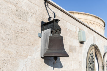 Obraz premium Copper bell hanging on the wall of the International Marian Centre in Nazareth city in Israel