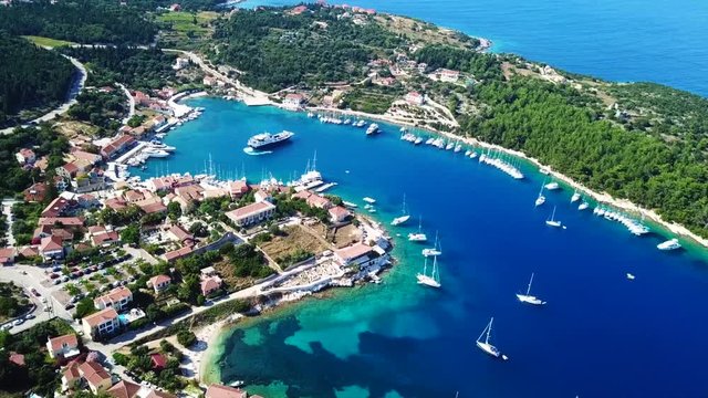 Aerial video from iconic traditional fishing village and bay of Fiskardo with beautiful houses and Ionian architecture, Cefalonia island, Greece