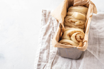 Obraz na płótnie Canvas Raw cinnamon bread in a baking dish. Copy space.