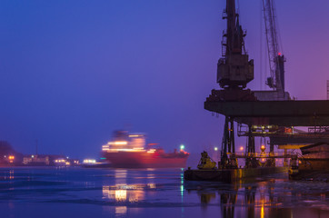 SEAPORT AT DAWN - The cargo ship maneuvers to transhipment wharf in Swinoujscie