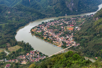 Fototapeta na wymiar View from the top Viewpoint of Nong Khiaw - a secret village in Laos. Stunning scenery of limestone cliff valley covered with green rainforest jungle mysterious clouds. A gem of north Laos.