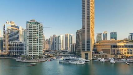 Obraz premium Aerial vew of Dubai Marina with shoping mall, restaurants, towers and yachts timelapse, United Arab Emirates.