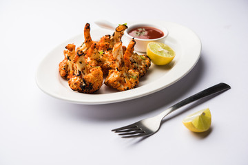Tandoori Gobi / Roasted cauliflower Tikka is a dry dish made by roasting Cauliflowers in Oven/Tandoor. It's  popular starter food from India. served with ketchup. selective focus