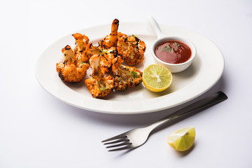 Tandoori Gobi / Roasted cauliflower Tikka is a dry dish made by roasting Cauliflowers in Oven/Tandoor. It's  popular starter food from India. served with ketchup. selective focus