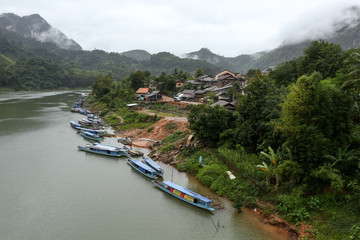 Naklejka premium Nong Khiaw is a village in a steep limestone cliff valley covered with jungle in the Luang Prabang Province of northern Laos. It's on the Nam Ou River, where tour boats and kayaks travel.