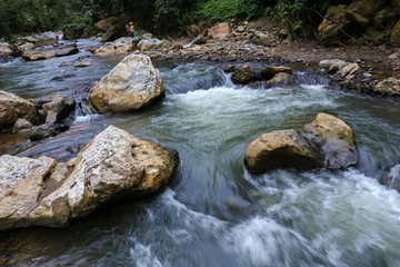 Naklejka na ściany i meble Strong mountain river streams pass through big stones in Nong Khiaw - a village in the Luang Prabang Province of northern Laos surrounded by steep limestone cliffs covered with jungle.