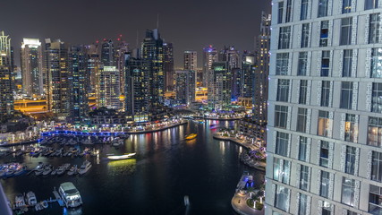 Luxury Dubai Marina canal with passing boats and promenade night timelapse, Dubai, United Arab Emirates